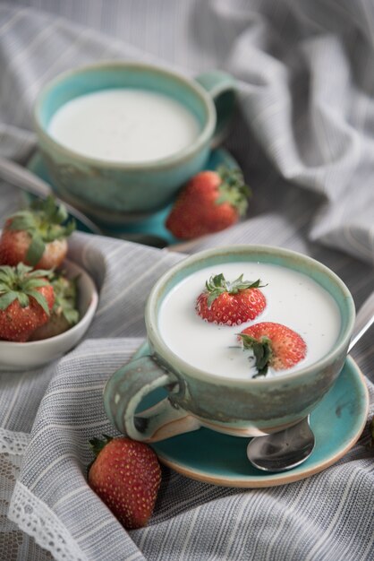 Foto fresas y bebidas de leche sobre fondo de tela