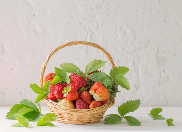 Fresas en canasta en pared blanca