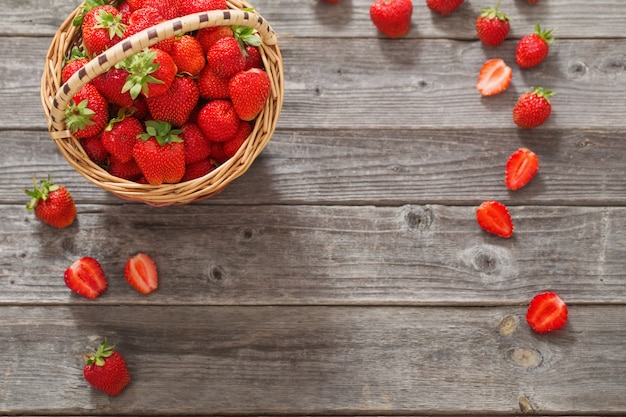 Fresas en cesta en mesa de madera