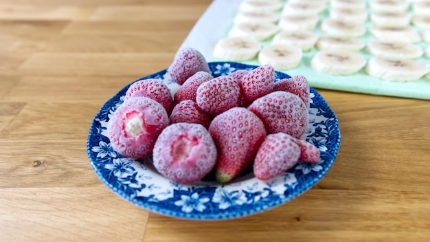 Fresas congeladas y plátano en la mesa de madera