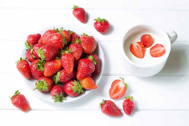 Fresas con crema sobre un fondo blanco. Alimentación saludable.