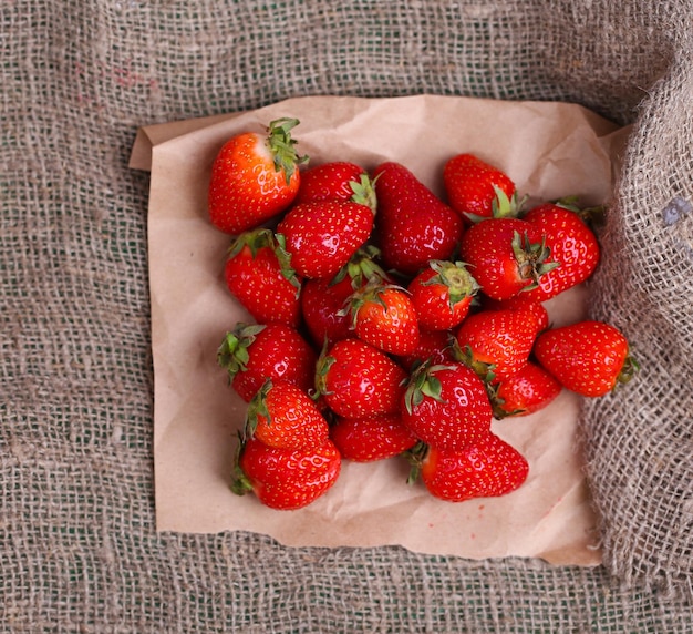 Fresas dulces maduras sobre fondo de tela de saco