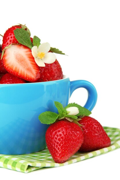 Foto fresas dulces maduras en taza azul aisladas en blanco