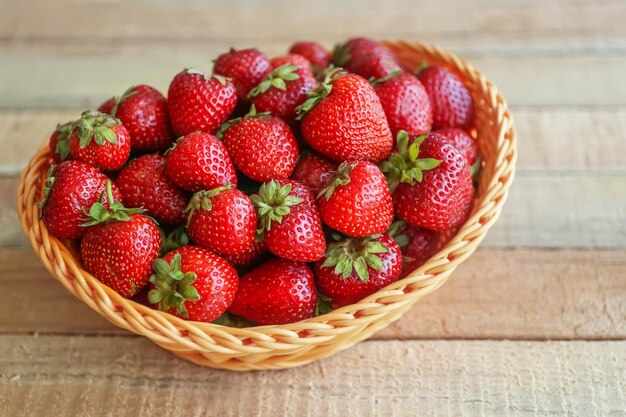 Fresas fresas en una canasta de mimbre en la mesa