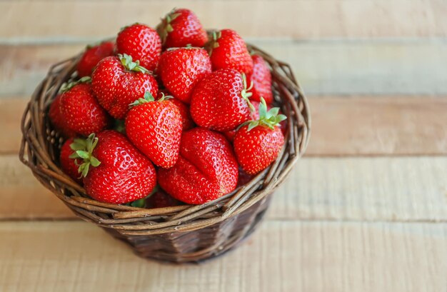 Fresas fresas en una canasta de mimbre en la mesa