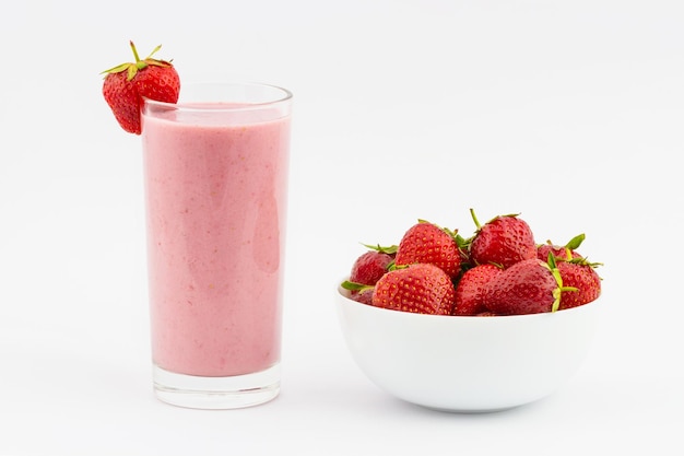 Fresas frescas en un bol con un vaso de batido