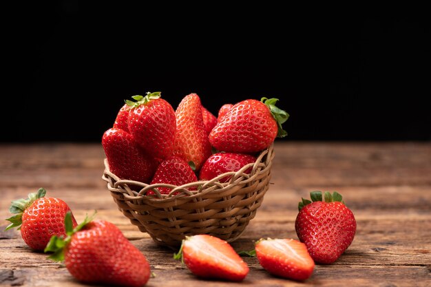 Fresas frescas en una canasta en la mesa de madera antigua cerrar