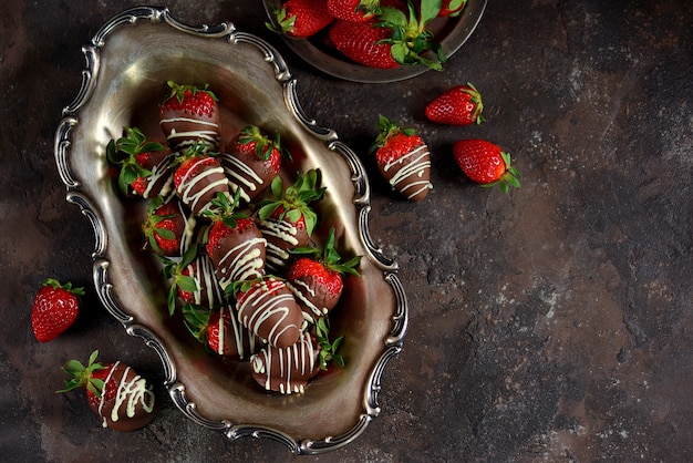 Fresas frescas en chocolate con leche y chocolate blanco