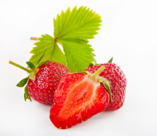 Fresas frescas cortadas con hojas aisladas en blanco