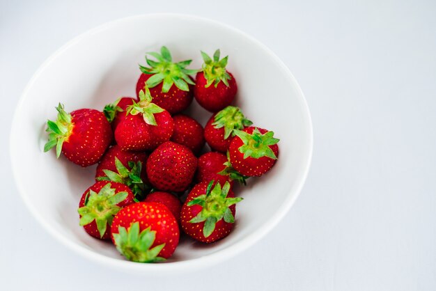 Fresas frescas crudas dieta saludable fruta en placa, aislado en blanco, ver arriba, plano de cerca, copyspace para texto, marco