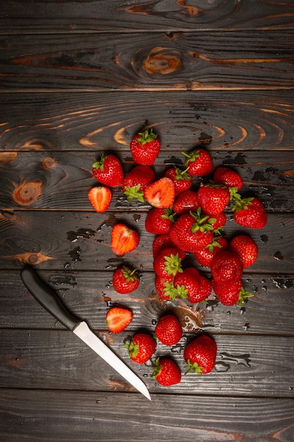 Fresas frescas con un cuchillo sobre una mesa de madera