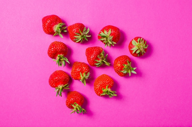 Fresas frescas se encuentran en una superficie de color rosa. El concepto de alimentación saludable. Comida dietética