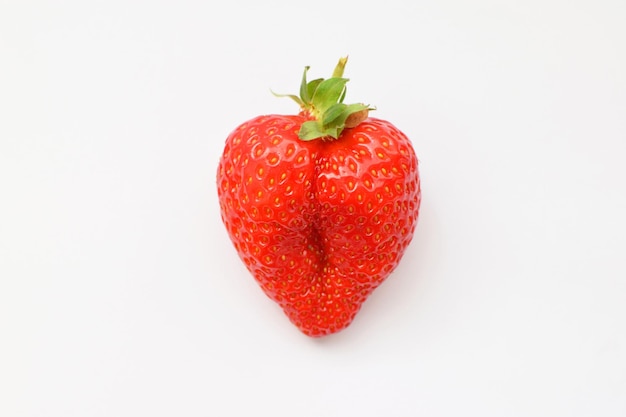 Una fresas frescas en forma de corazón sobre un fondo blanco.