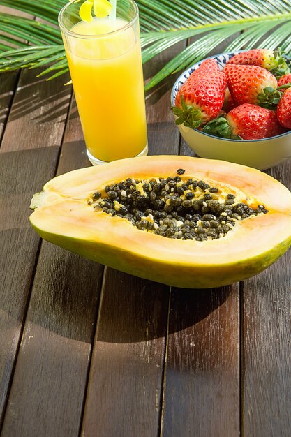 Fresas frescas a la mitad de papaya madura en un tazón Jugo de piña