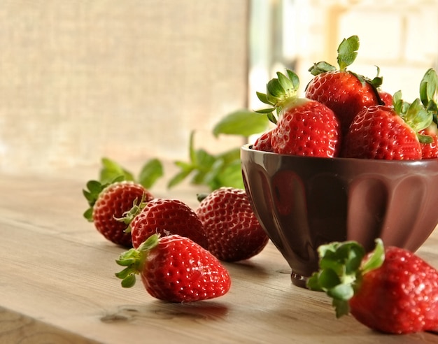 Fresas frescas en un plato y tela marrón