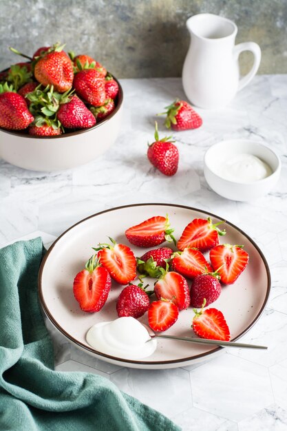 Fresas frescas en rodajas y yogur en un plato sobre la mesa Postre vitamínico saludable Vista vertical