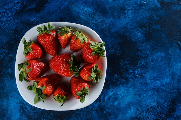 Fresas frescas sobre una base con textura azul