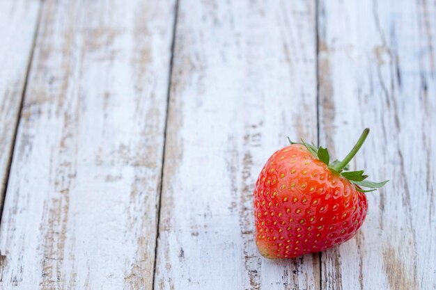 Fresas frescas sobre fondo blanco de madera vieja