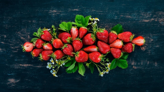 Fresas frescas Sobre un fondo de madera negra Vista superior Espacio de copia