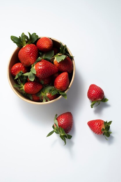 Fresas de fruta fresca en envases de papel sobre un fondo blanco Vista superior plana