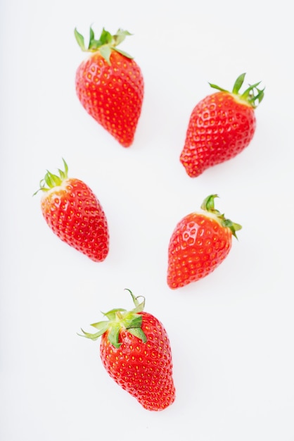 Fresas jugosas frescas aisladas sobre el escritorio blanco. Vista superior.