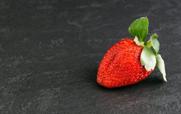 Fresas jugosas maduras en un fondo gris.