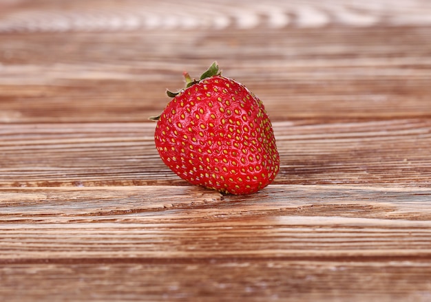 Fresas maduras, aisladas en la pared de madera. Vista superior