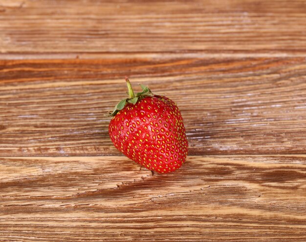 Fresas maduras, aisladas sobre fondo de madera. Vista superior