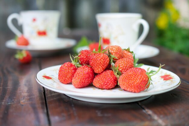 Fresas maduras apetitosas esparcidas en el plato blanco