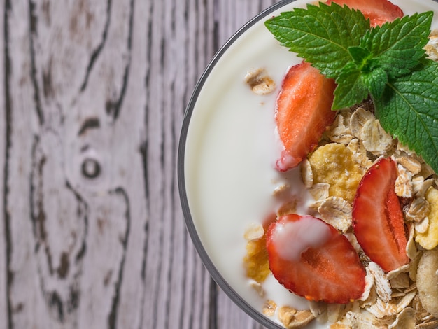 Fresas maduras con avena y yogur en un bol de vidrio