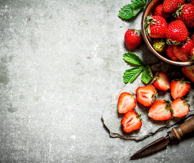 Fresas maduras con un cuchillo viejo