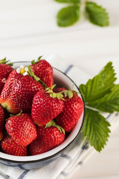 Foto fresas maduras frescas en un recipiente sobre un fondo blanco ecoproductos