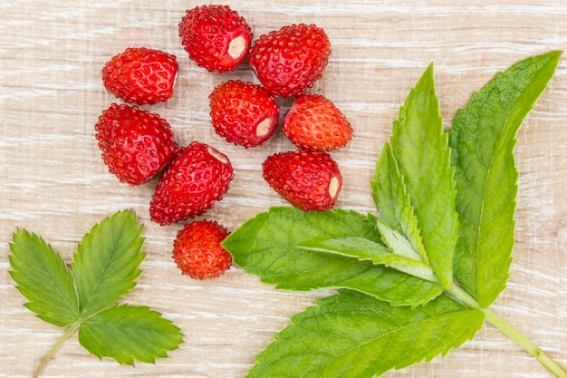 Fresas maduras y hojas de menta sobre una mesa