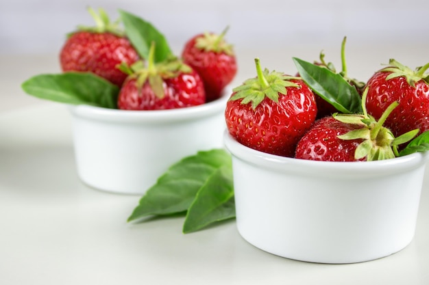 Fresas maduras y menta en un recipiente sobre una mesa