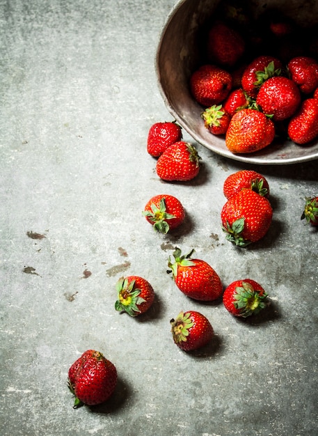 Fresas maduras en una olla vieja.