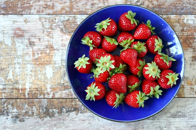 Fresas maduras en una placa azul.