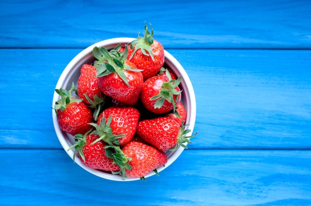 Fresas maduras en un recipiente blanco. Bayas frescas saludables. Vista superior