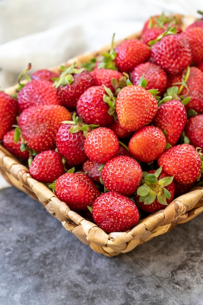 Fresas maduras sobre un fondo oscuro Fresas frescas en una cesta Alimentos orgánicos de cerca