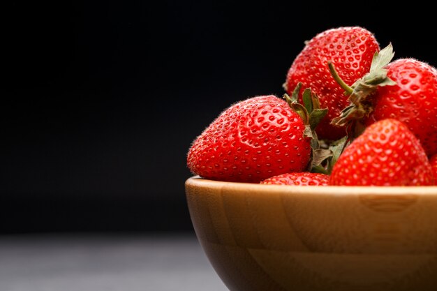 Fresas maduras en tazón de madera