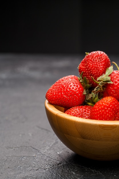 Fresas maduras en tazón de madera