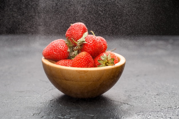 Fresas maduras en tazón de madera