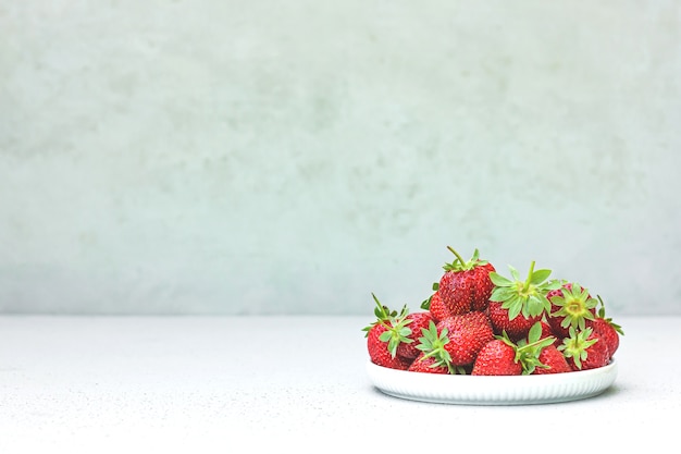 Fresas orgánicas deliciosas rojas jugosas maduras frescas en un recipiente blanco