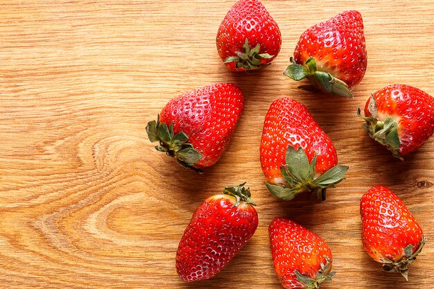 Fresas orgánicas maduras en el fondo de madera, cierre para arriba.