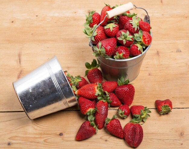 Foto fresas en un pequeño cubo metálico