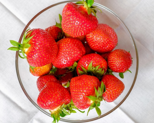 Fresas en un plato sobre un fondo blanco.