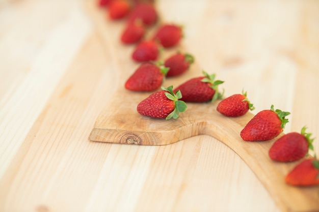 Fresas rojas frescas en la mesa de madera