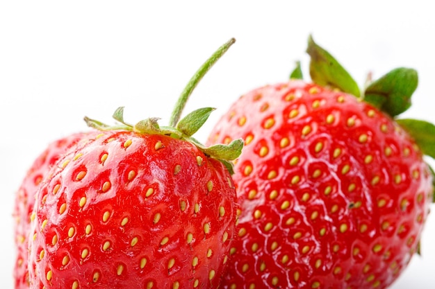 Fresas rojas hermosas y maduras sobre un fondo blanco