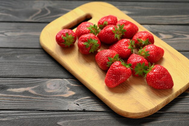 Fresas rojas y jugosas sobre una mesa rústica de madera El concepto de bocadillos saludables y dietéticos