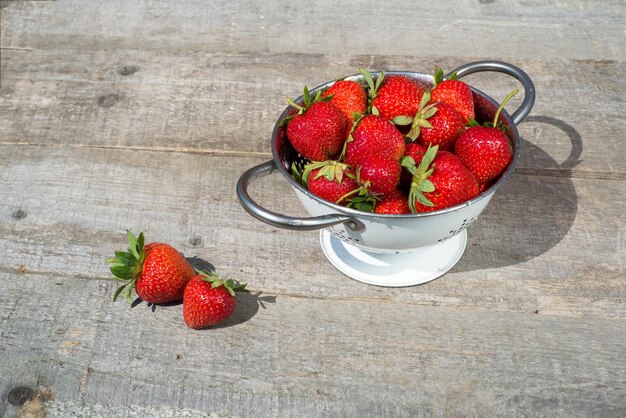 Fresas rojas maduras en el espacio de copia de la vista superior de la mesa de madera