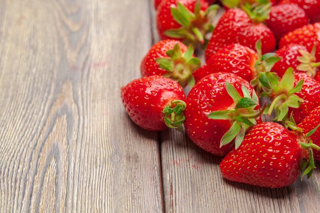 Fresas rojas maduras en mesa de madera de cerca